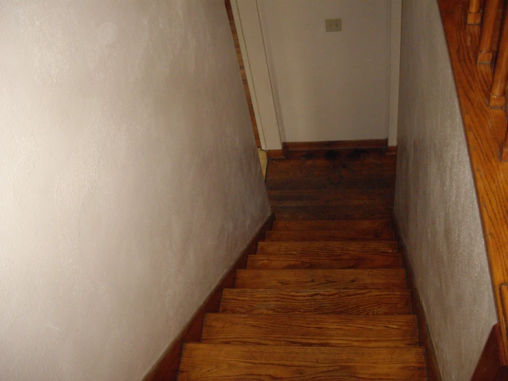 a hallway with an all wood floor and stair way