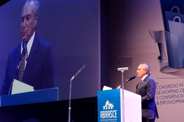 the man stands at the podium while speaking