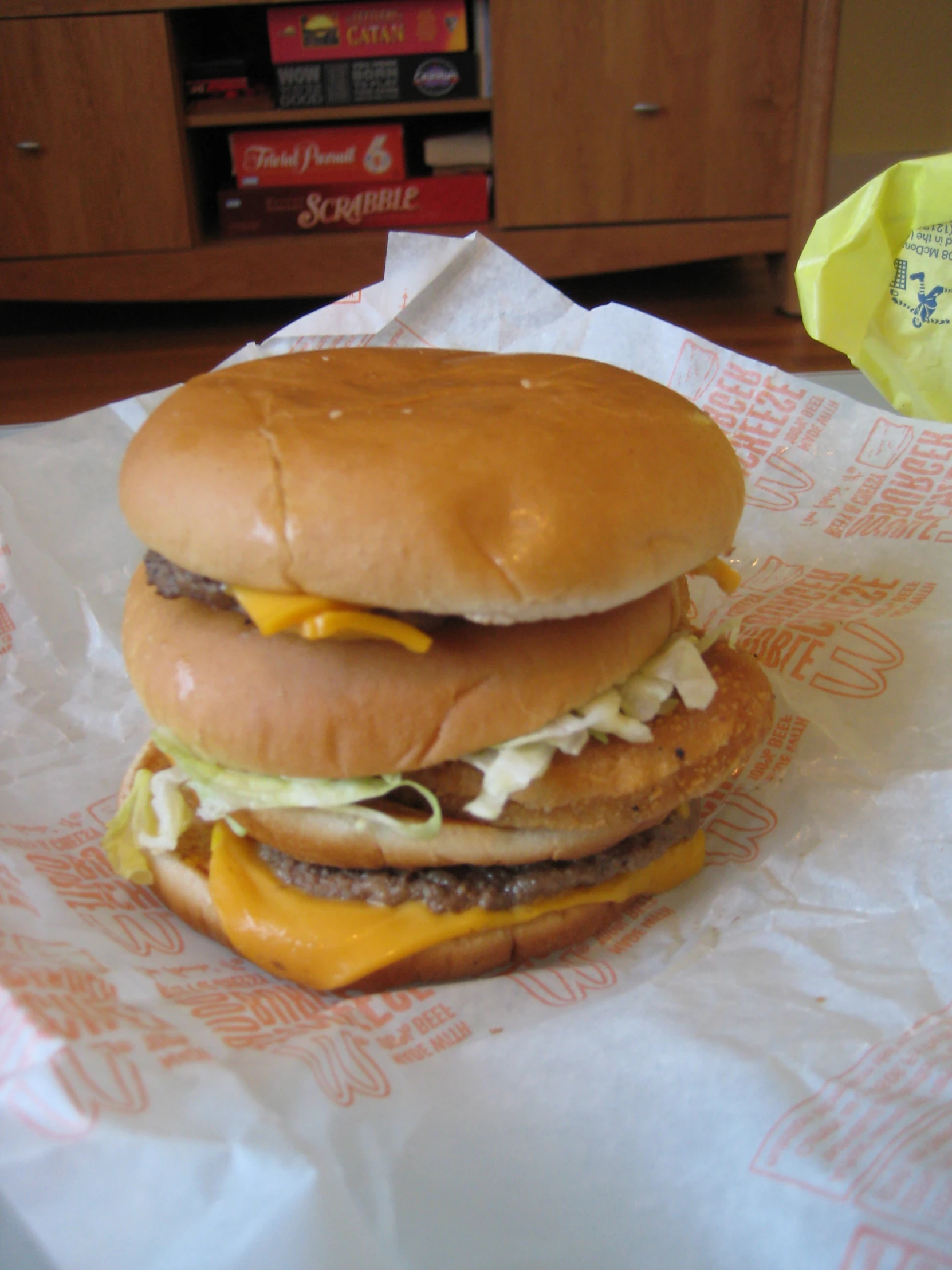 a hamburger with meat and cheese on a paper wrapper