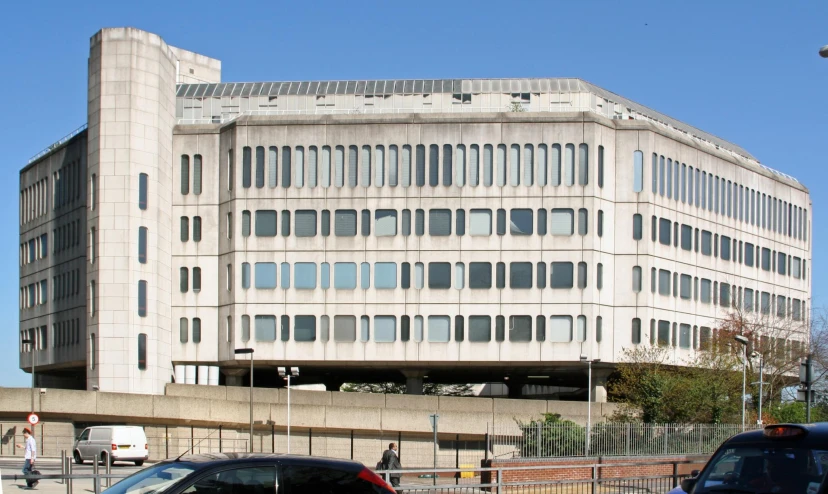 several cars parked in front of a big white building