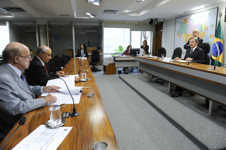 men sitting at a conference table holding papers