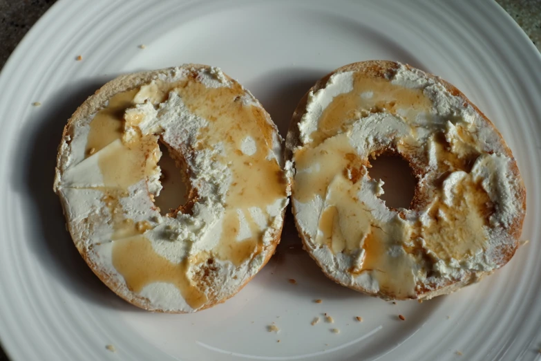 two donuts with cream and powdered sugar on top