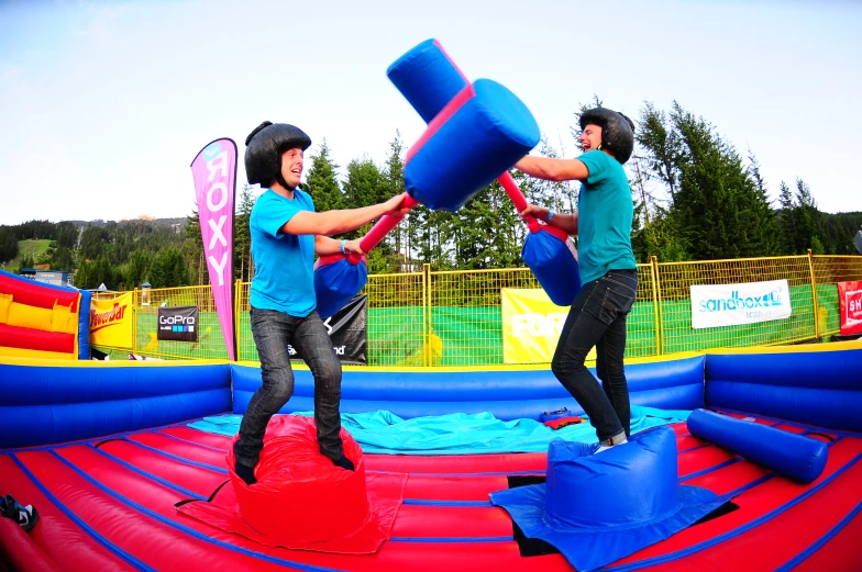 two people playing in a bouncy park with blue balls