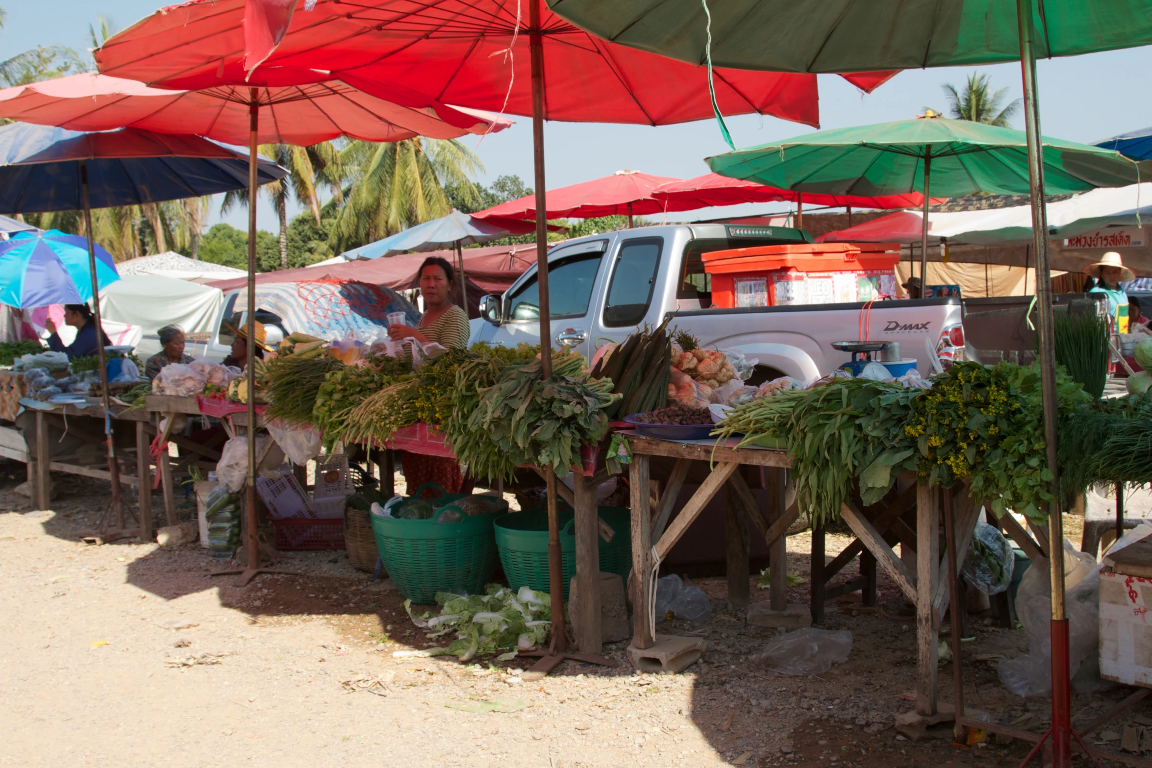 a farmers market is seen with umbrellas