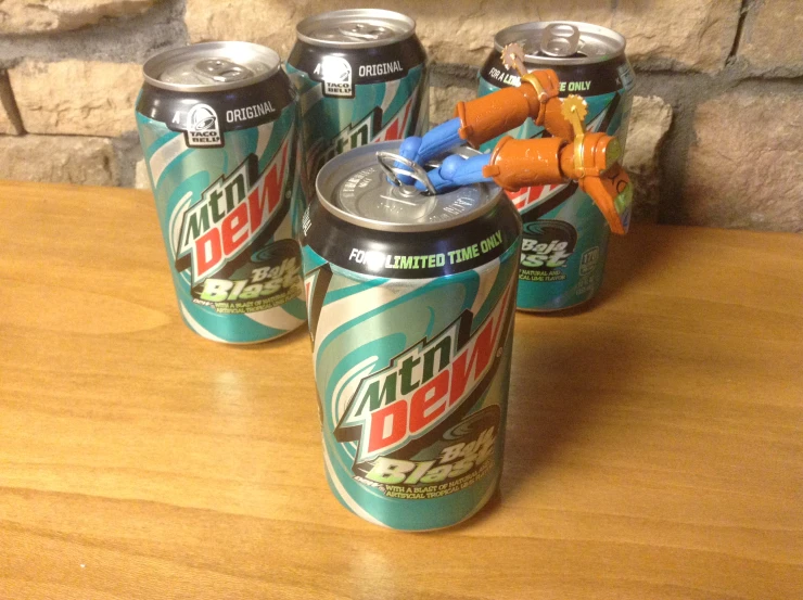 five cans of soda with toy carrots in them