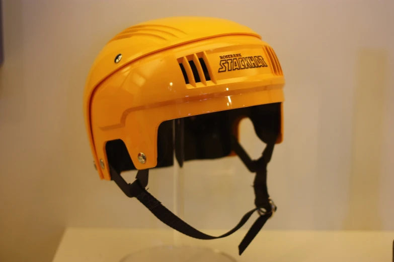 a hockey helmet sits on a glass shelf