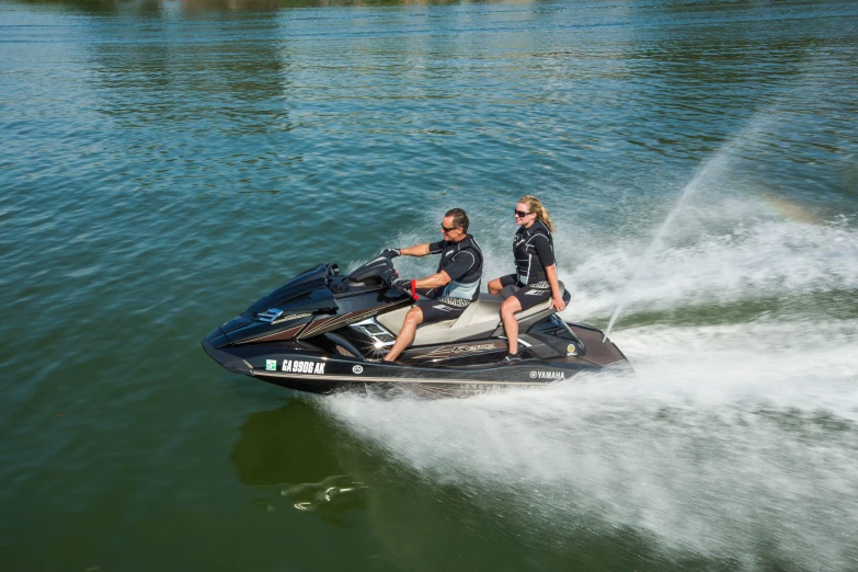 a man and a woman riding on the back of a jet ski