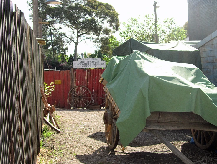 a covered buggy sits parked in an alleyway