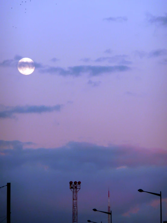 an image of the moon rising over a city