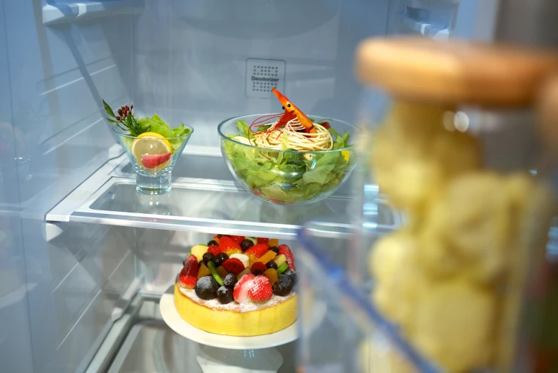 two salads and a salad on the shelf in a fridge