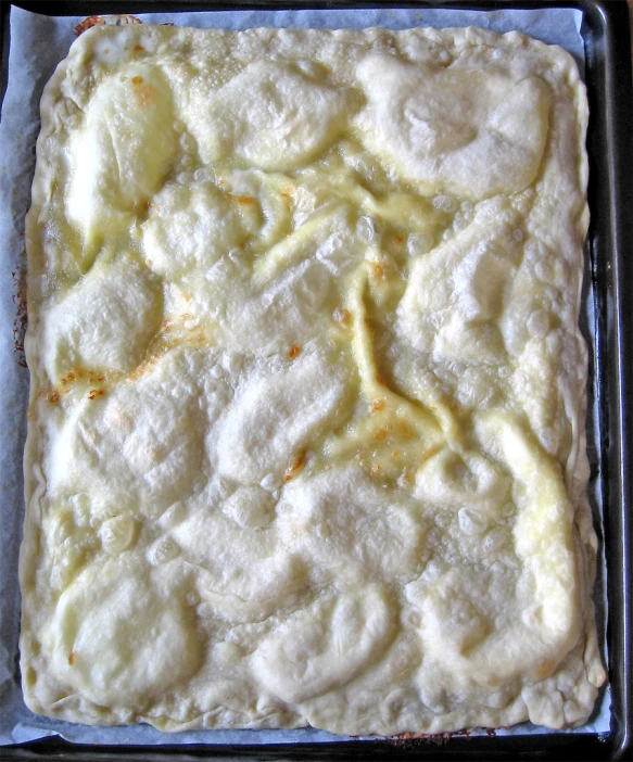 a baking pan full of cooked and uncooked cheese
