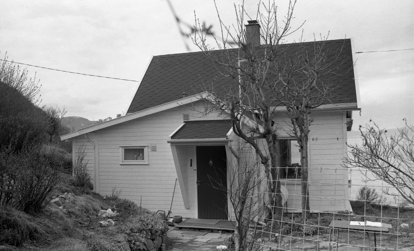 a black and white po of a house next to a fence