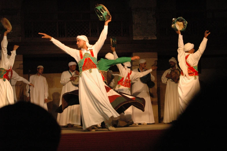 men performing a song with their arms up and hands raised