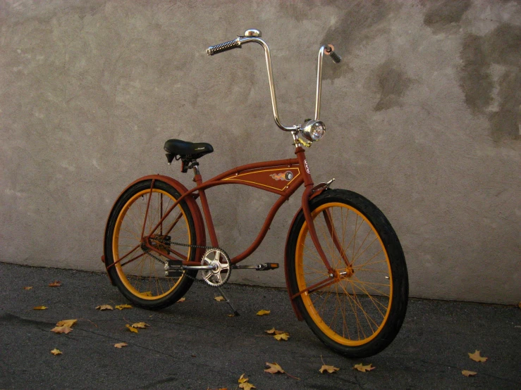 the red bike is parked near the wall