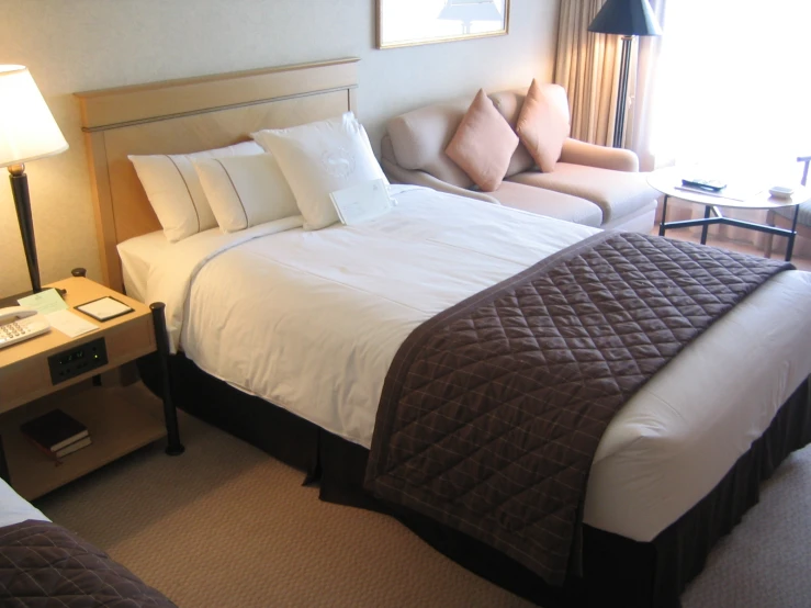 a el room has white bedding and brown accents