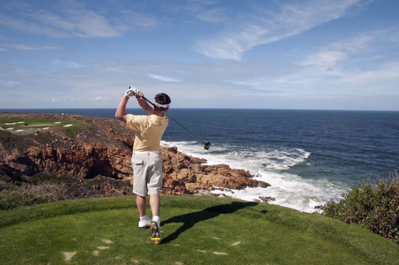 a man hitting his tee s on the ocean