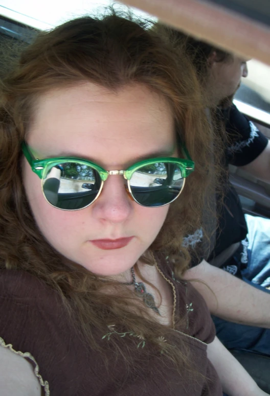 a woman with sunglasses sitting in the backseat