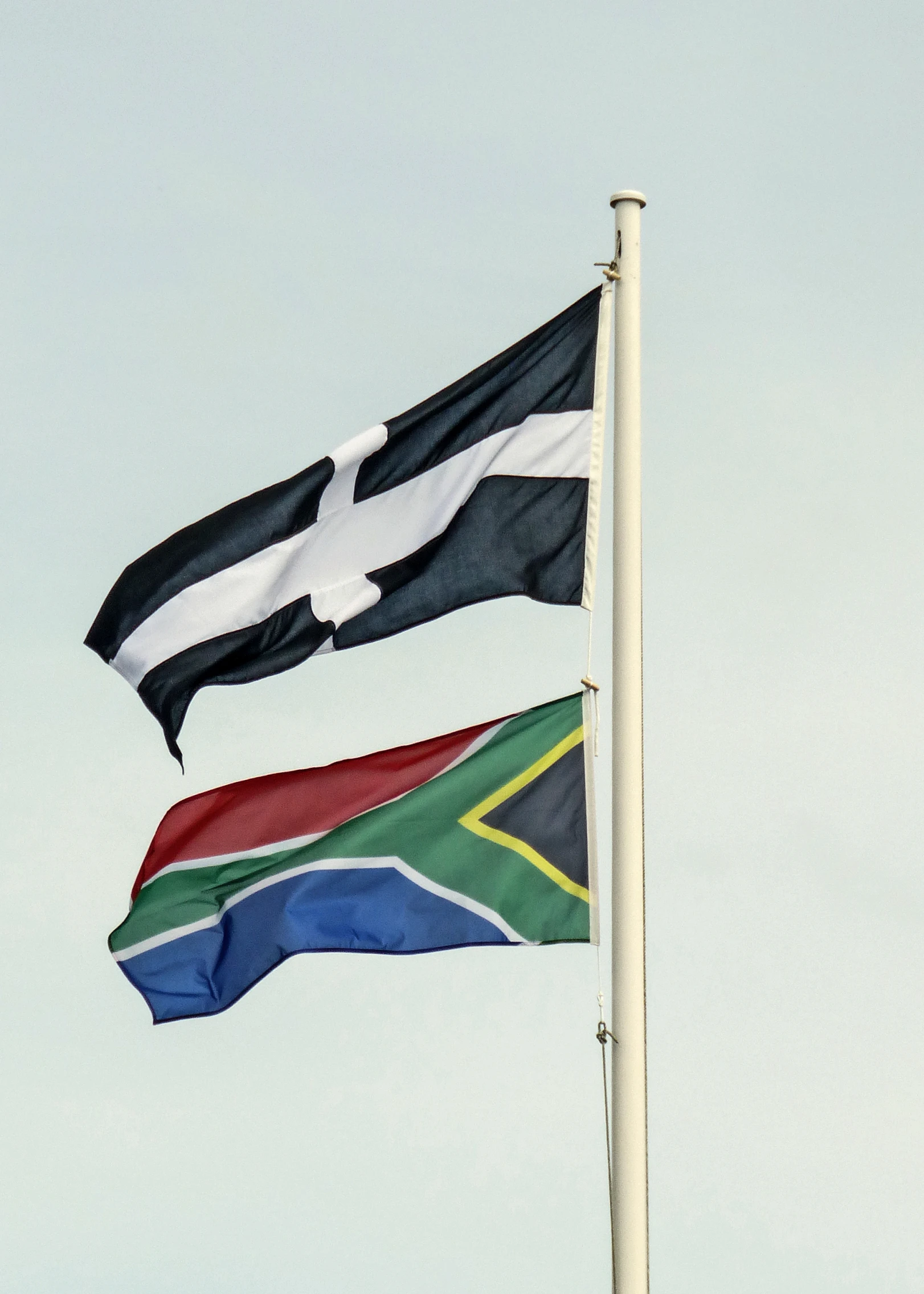 two flags are flying in the wind on a windy day