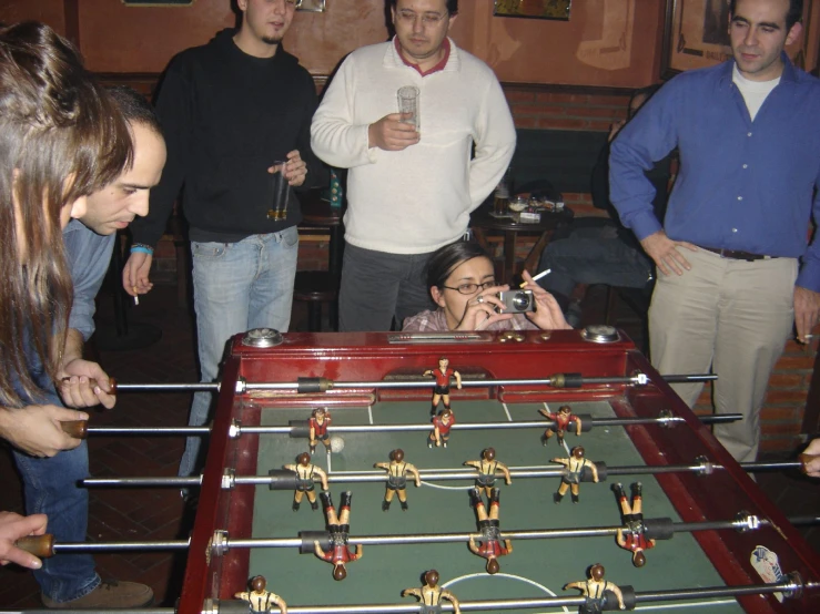 group of people playing table soccer in a living room