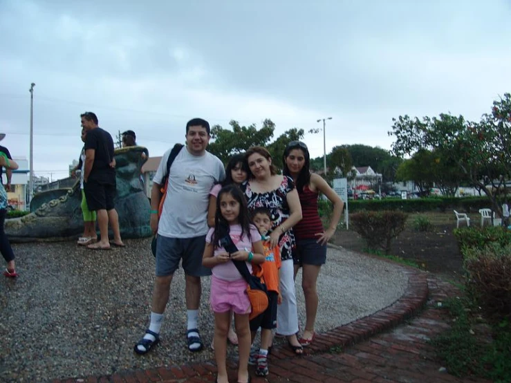 a family poses for a picture by an outdoor rock garden