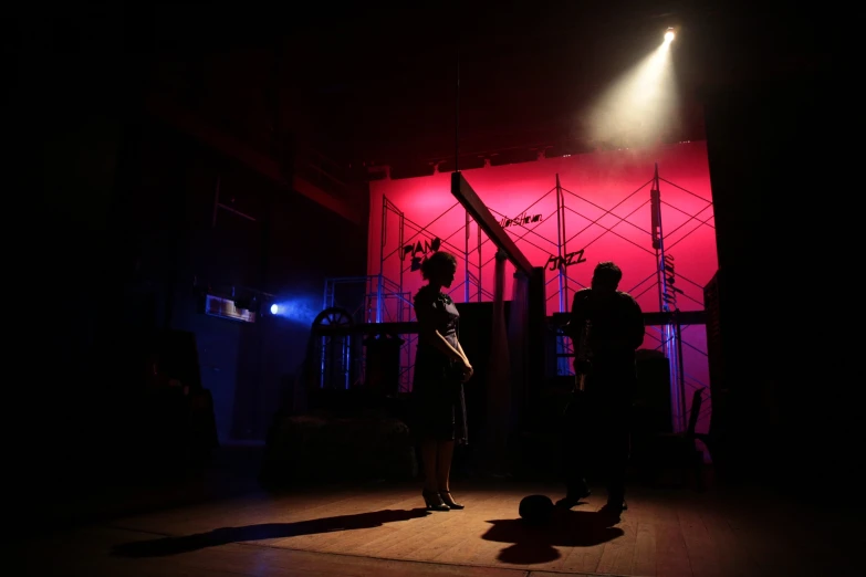 a couple of people standing in front of some red lighting