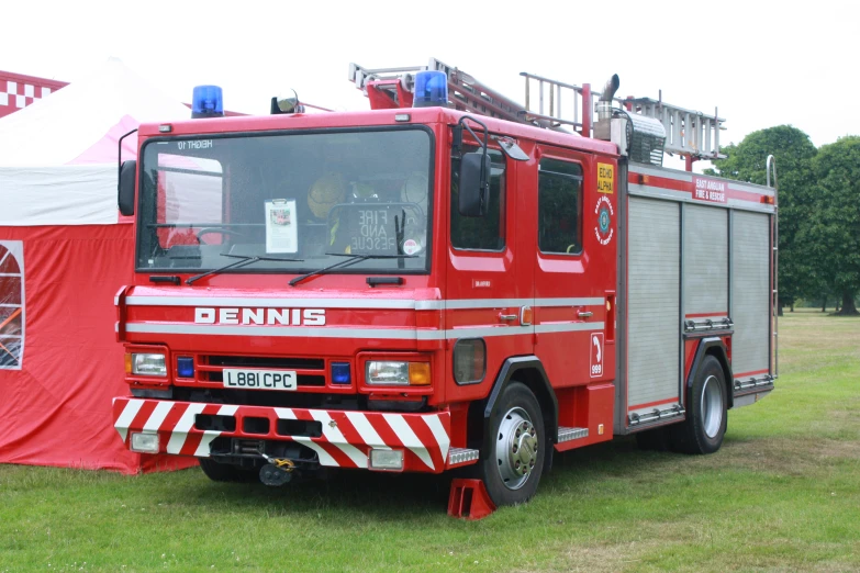 a large red fire truck parked on top of a field