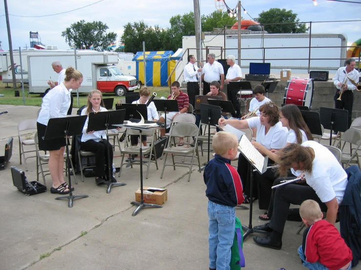 a group of people playing music outside on a sidewalk