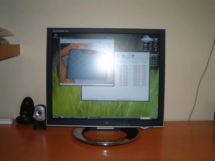 a computer monitor sits on a desk with a mouse next to it