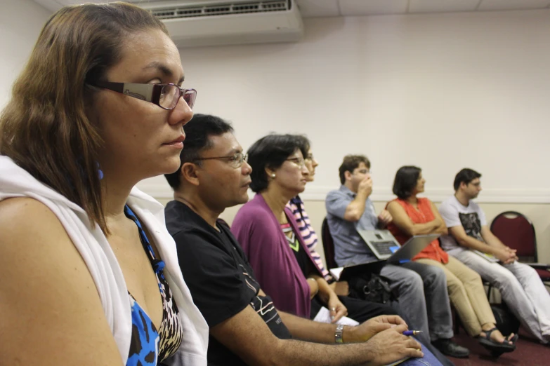 many people are listening and sitting next to each other