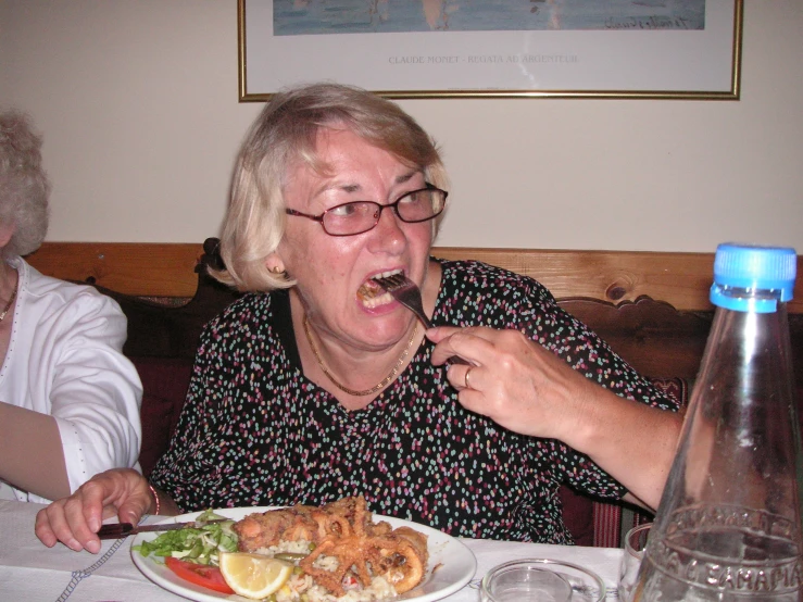 a lady holding a fork in her mouth eating food