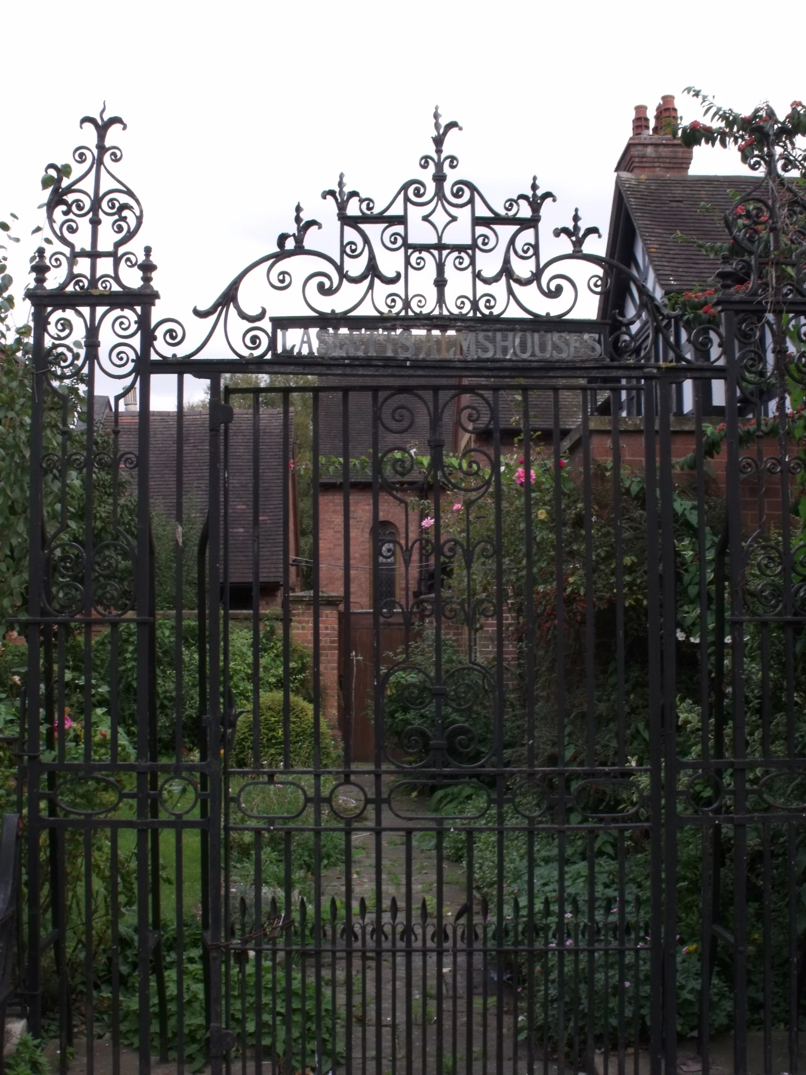 this is an iron gate surrounded by vines and a house