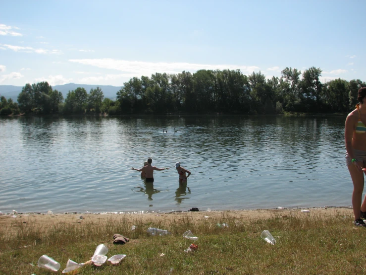 two people are wading in the water of a lake