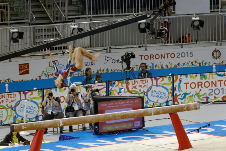 men performing on a balance beam and some people looking at them