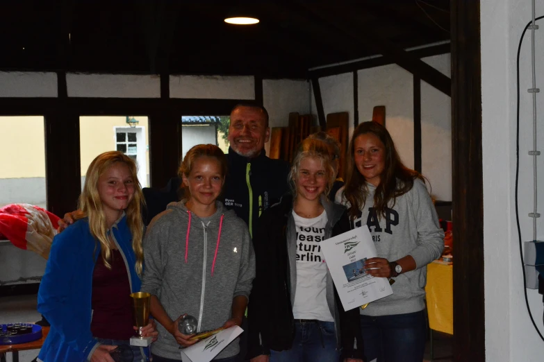 several young people and a man posing for a picture