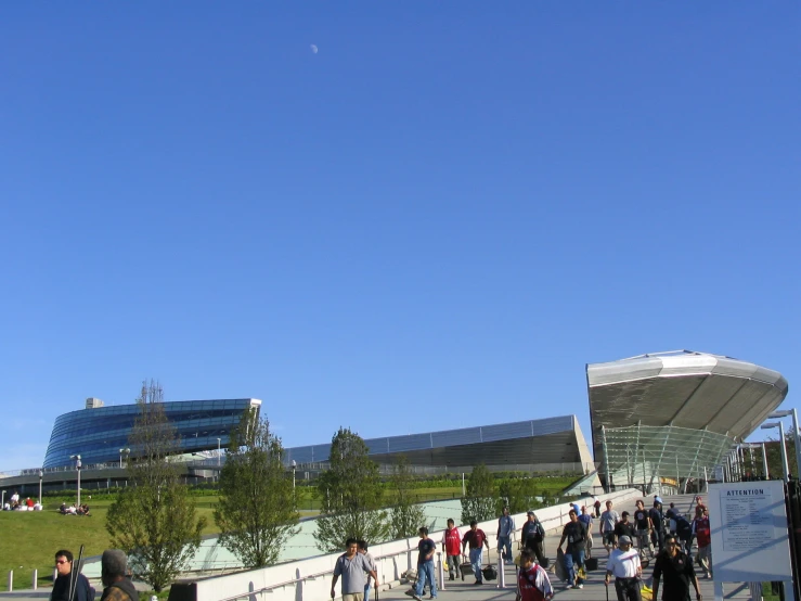 a group of people walking across a walkway in the park