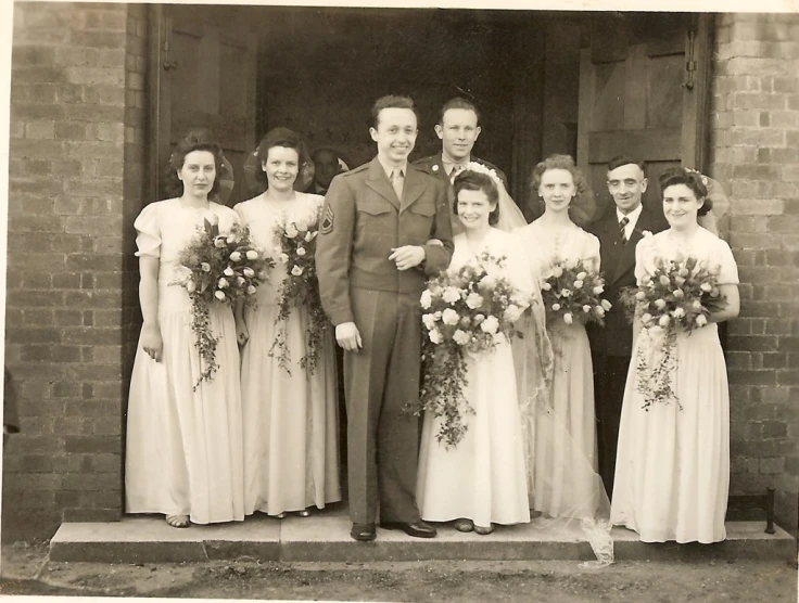 an old time po of a wedding party posing for a picture