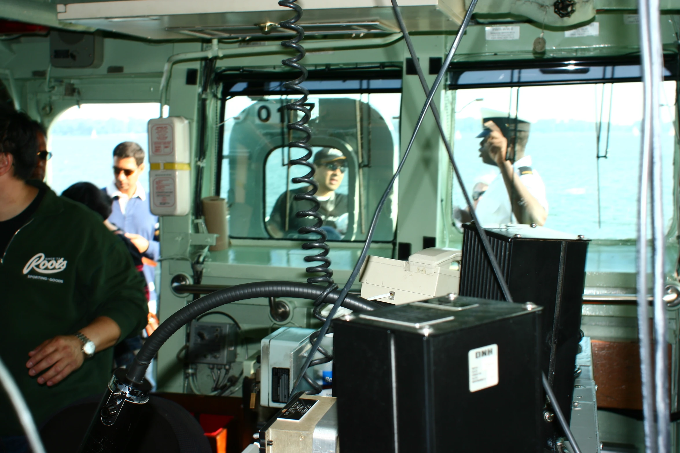 a man standing inside of a green boat near a monitor