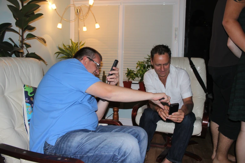 two men sitting on a couch in a living room