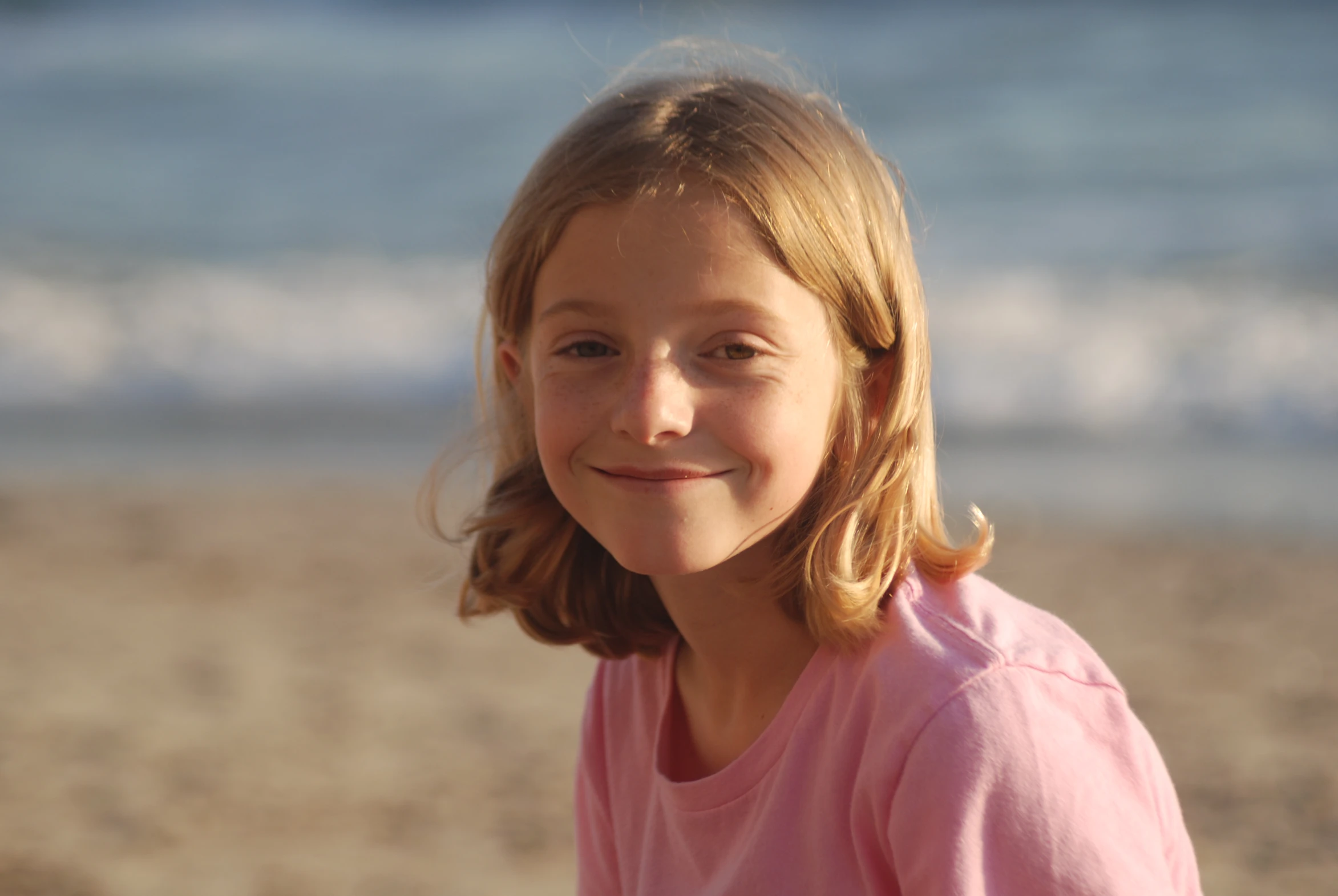 a smiling  wearing a pink shirt on a beach