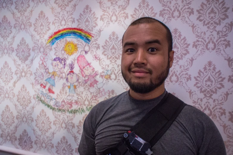 a man standing next to a painting on a wall