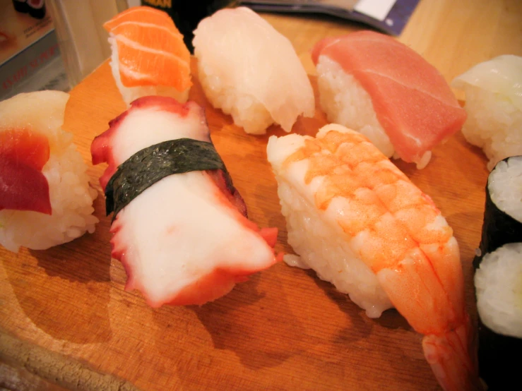 several different types of sushi on a wooden table