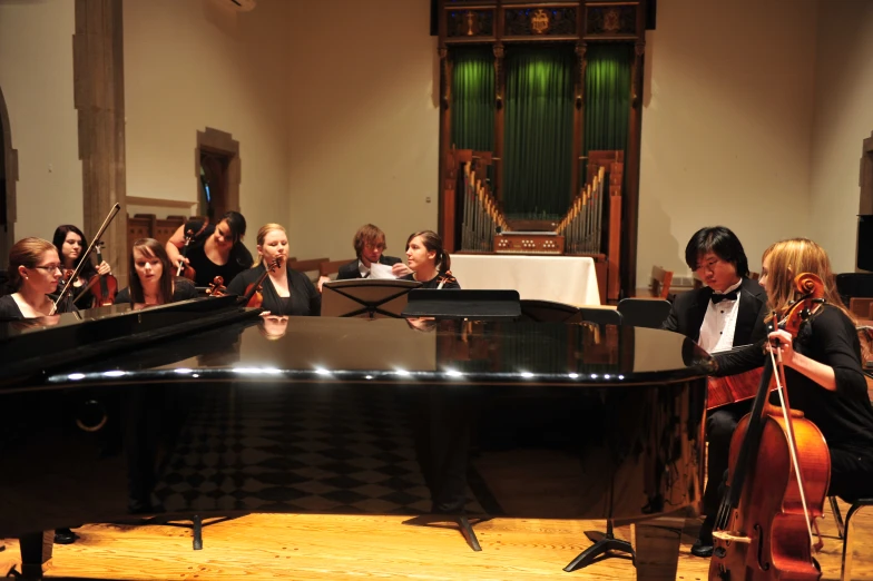 a piano and orchestra with a boy in black playing a piano