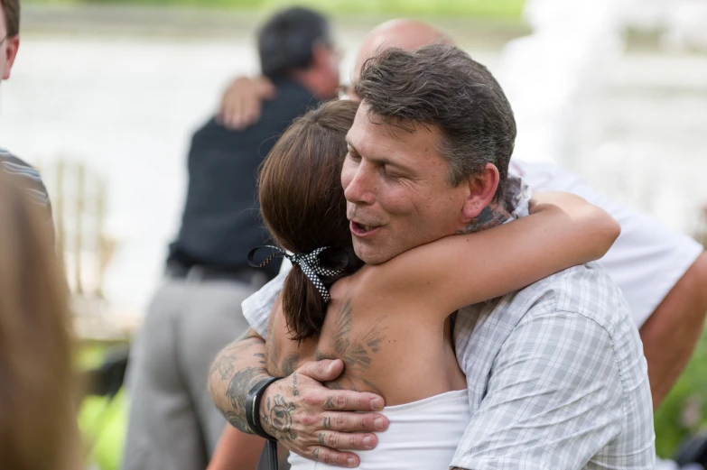 man hugging a woman while sitting on a bench