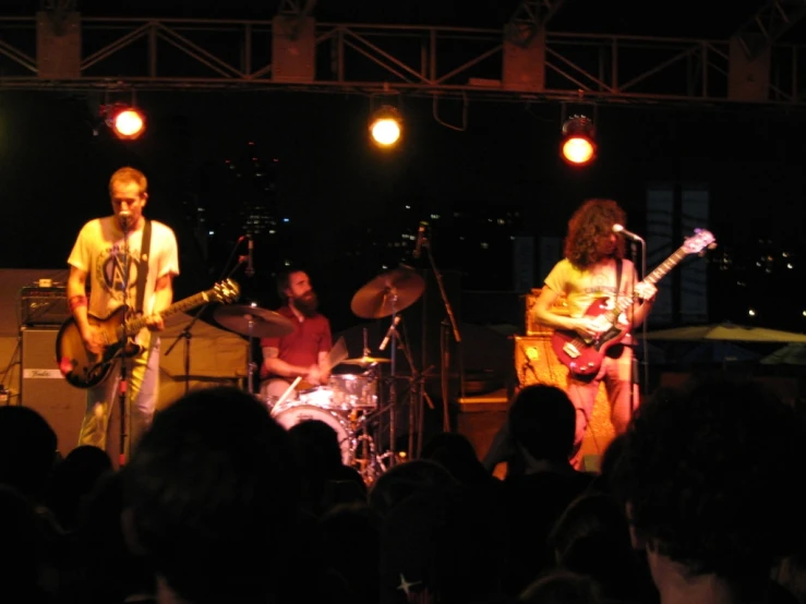 a band on stage playing with some people watching