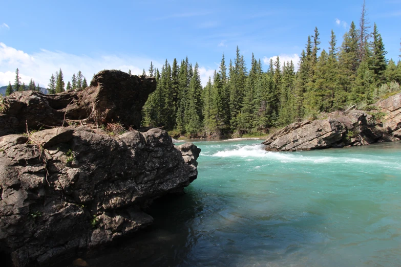 the water is crystal blue as it moves along the bank