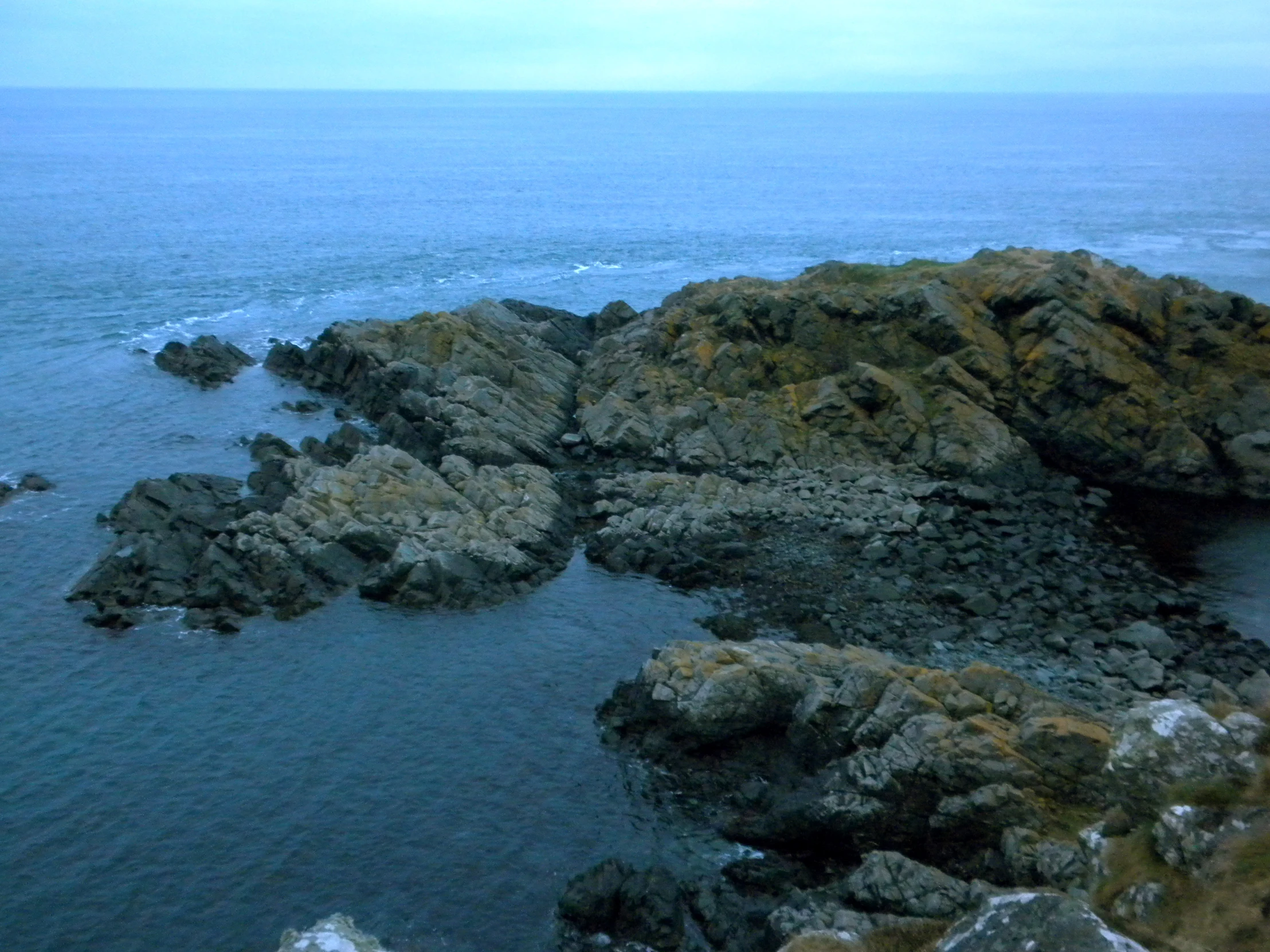 a rocky beach next to a body of water