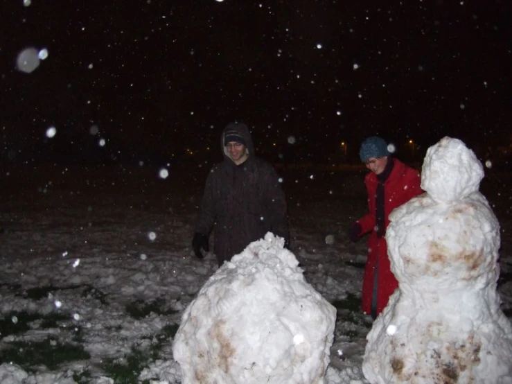 a man and a woman are outside in the snow