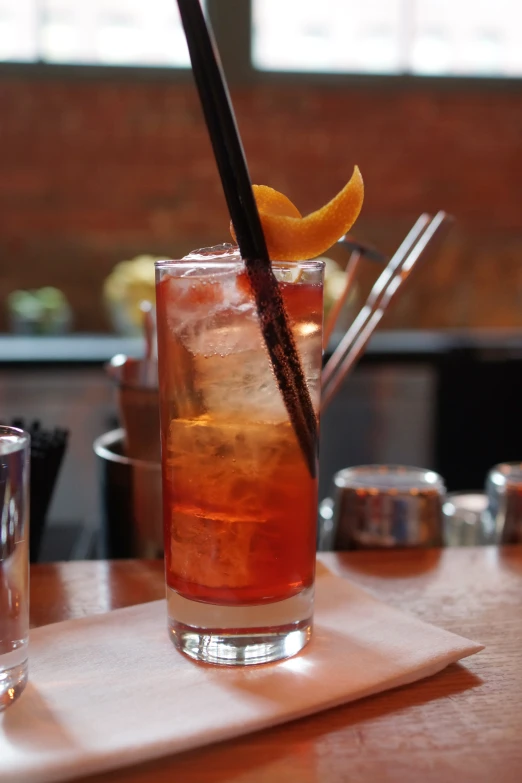 a glass of cocktail sitting on top of a wooden table