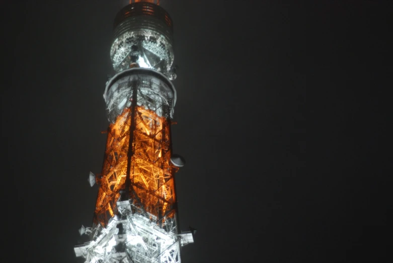 illuminated tower with many lights and birds around it