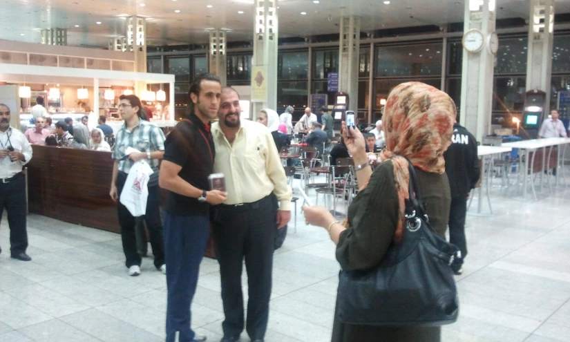 a man holding soing up to his face in a mall